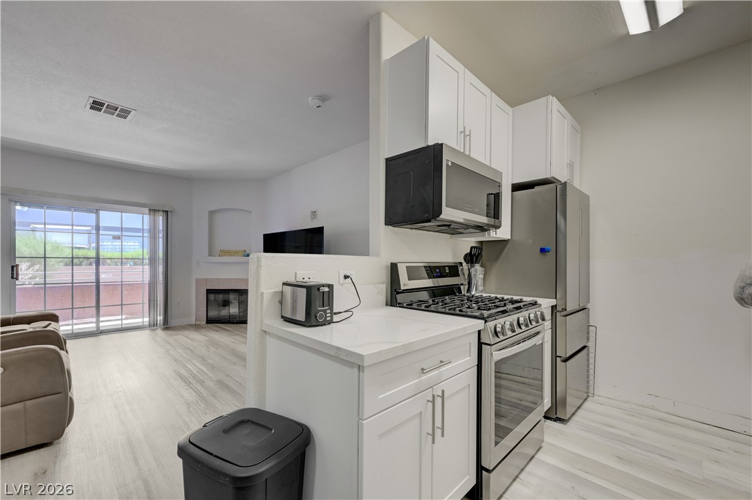 4730 East Craig Road, Unit 1155 Las Vegas, NV 89115 - Photo 12 of 41 An open concept living area boasts a modern kitchen with stainless steel appliances and durable flooring.