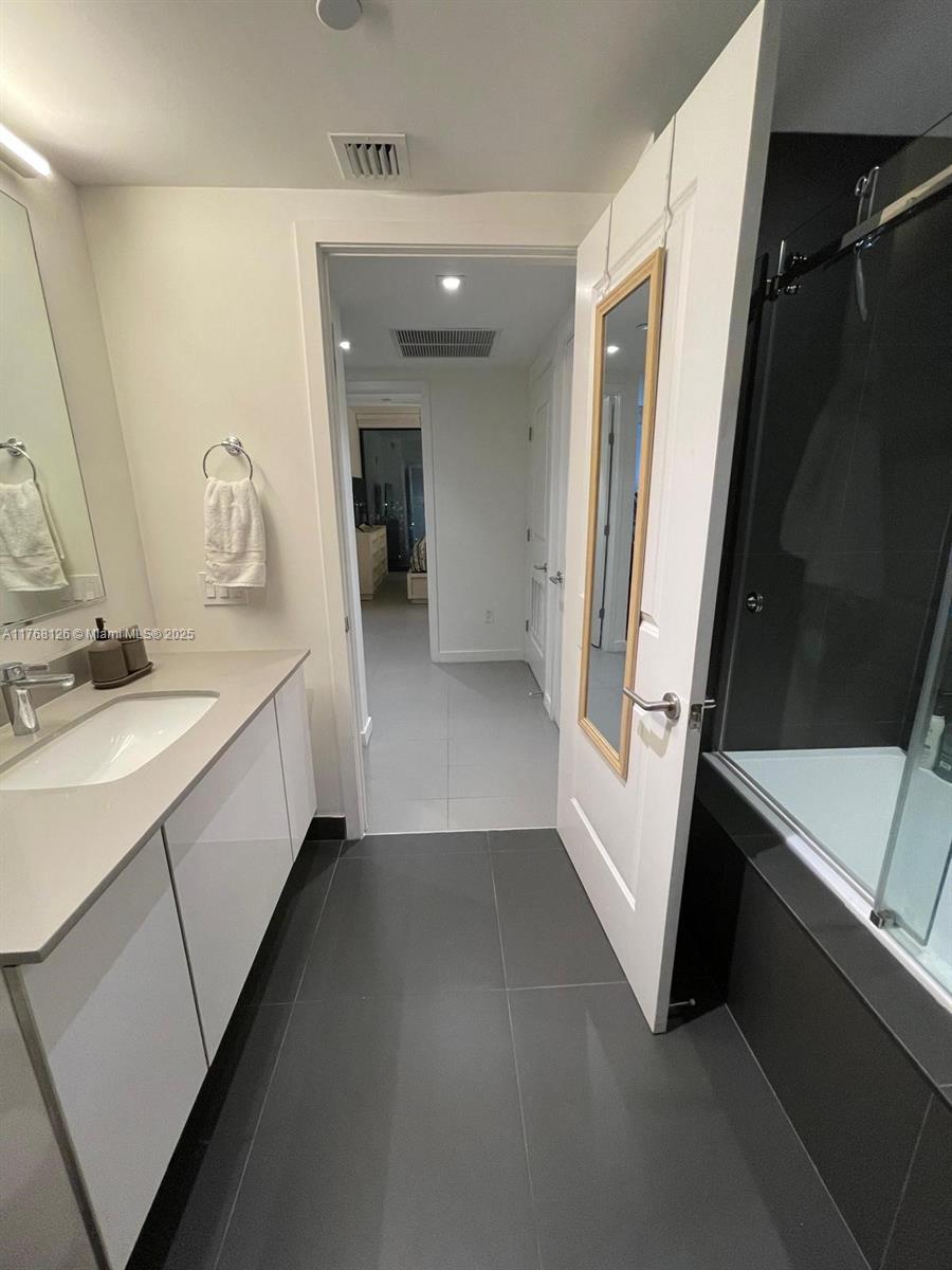 Omni Miami, FL 33132 - Photo 9 of 11 a bathroom with a sink a mirror and a bathtub