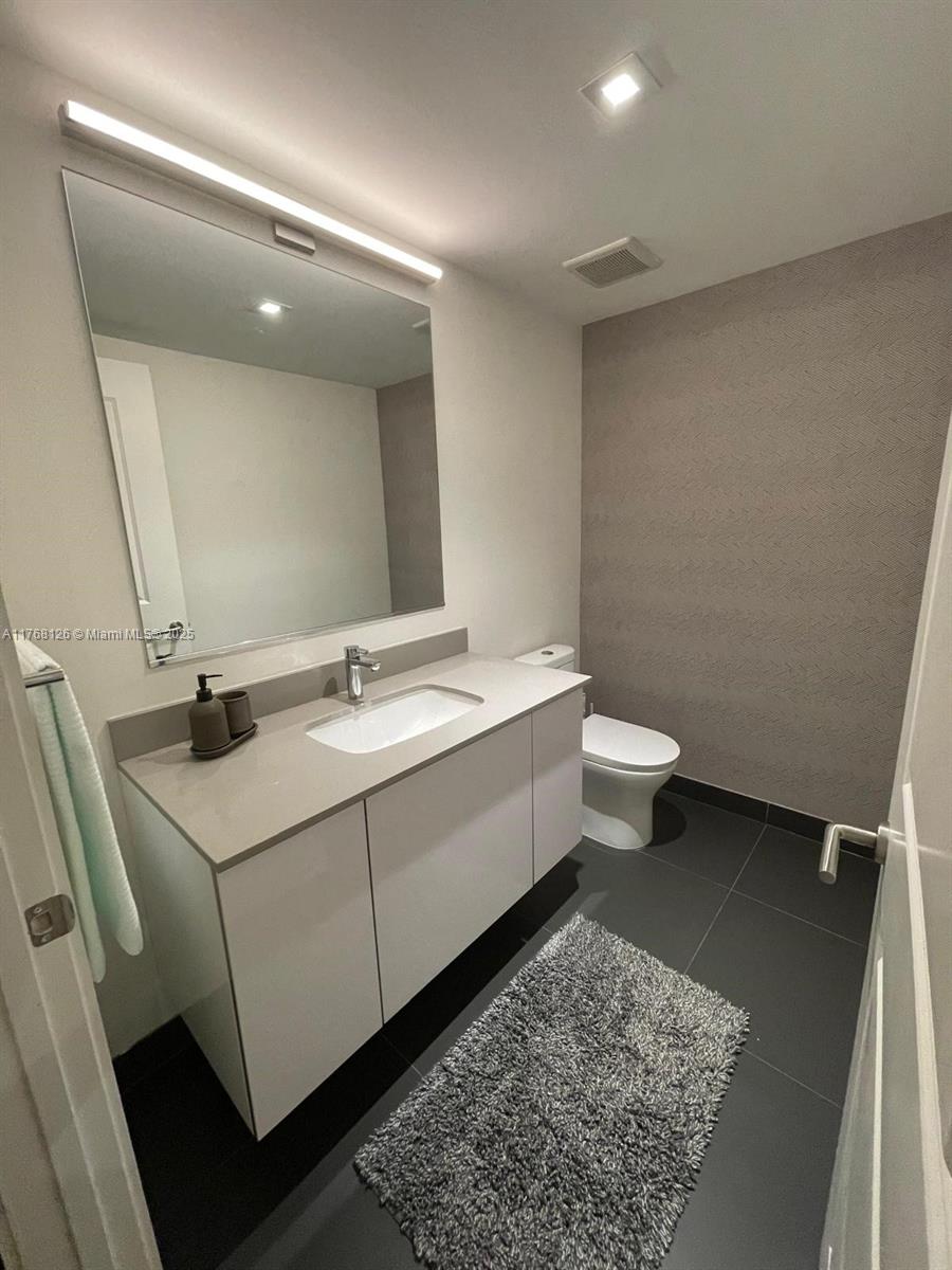 Omni Miami, FL 33132 - Photo 10 of 11 a bathroom with a sink and mirror with toilet