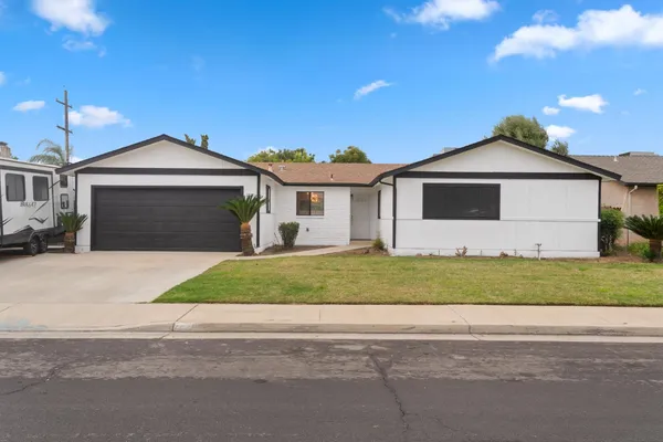 a front view of a house with a garden and garage