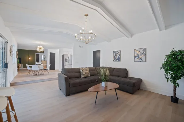 a living room with furniture and a chandelier