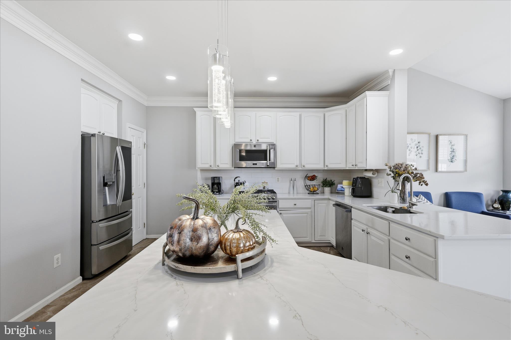 6711 Selbourne Lane Gainesville, VA 20155 - Photo 13 of 55 a kitchen with refrigerator a sink and cabinets