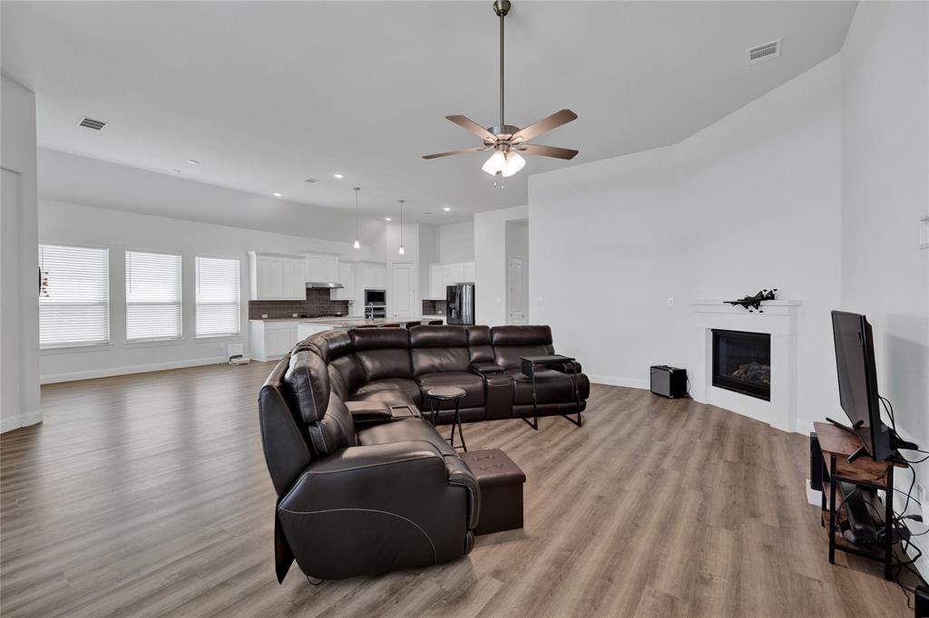 2307 Sam Street Mansfield, TX 76063 - Photo 17 of 23 Living room featuring light wood-style flooring, a ceiling fan, a glass covered fireplace, and recessed lighting