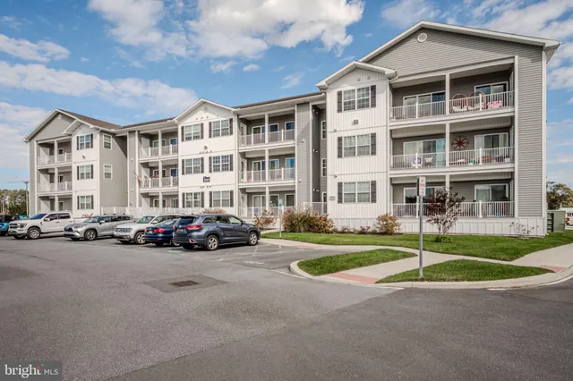 a front view of a residential apartment building with a yard