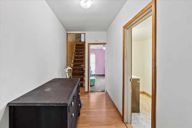 a view of a hallway with wooden floor and staircase