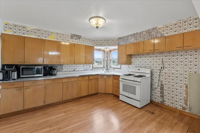 a kitchen with stainless steel appliances a sink window and cabinets
