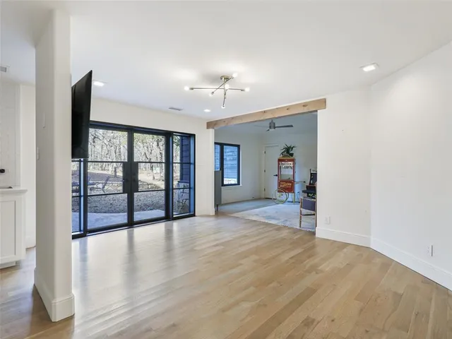 a view of an empty room with window and wooden floor