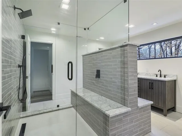 a bathroom with a double vanity sink a shower and a mirror