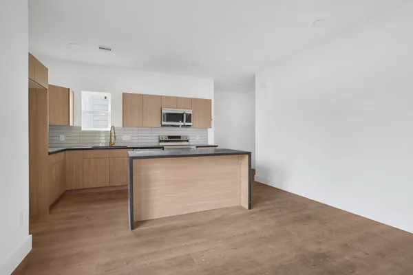 a kitchen with granite countertop white cabinets and stainless steel appliances