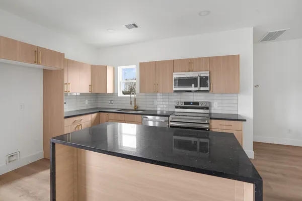 a kitchen with granite countertop a stove and a sink
