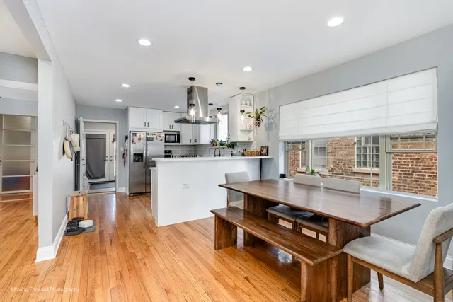 a kitchen with stainless steel appliances granite countertop a refrigerator a sink dishwasher a stove and white countertops with wooden floor