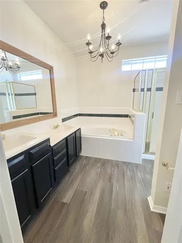 a bathroom with a sink a large mirror and a bathtub