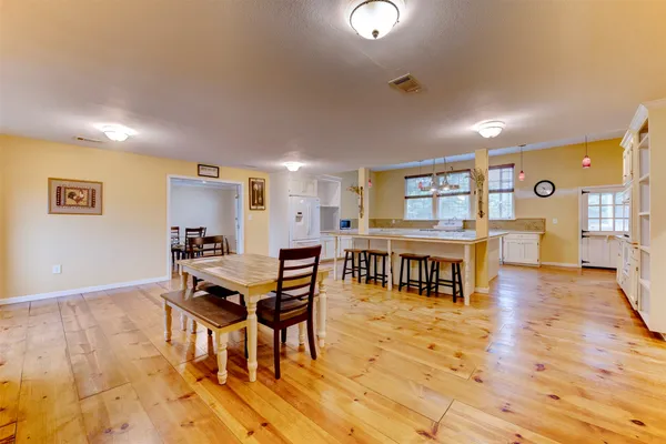 a living room with furniture and a table with wooden floor