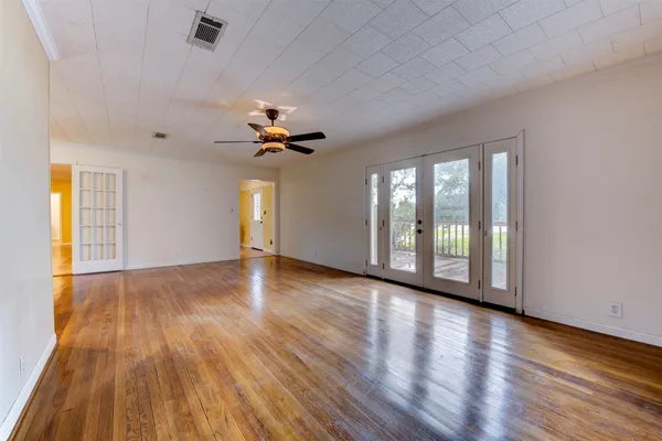 a view of an empty room with a window and wooden floor