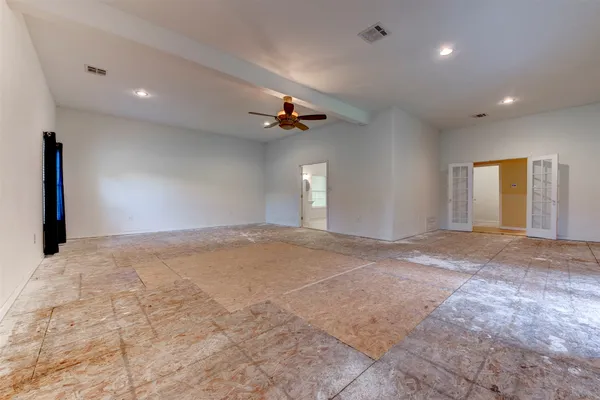 a view of an empty room and a ceiling fan