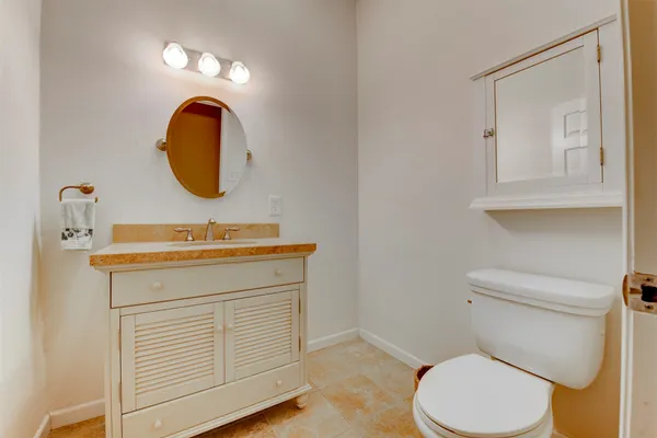 a bathroom with a sink mirror vanity and toilet