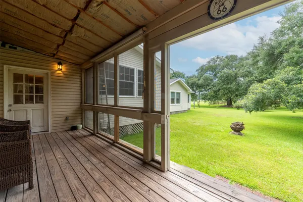 a view of a porch with wooden floor and yard