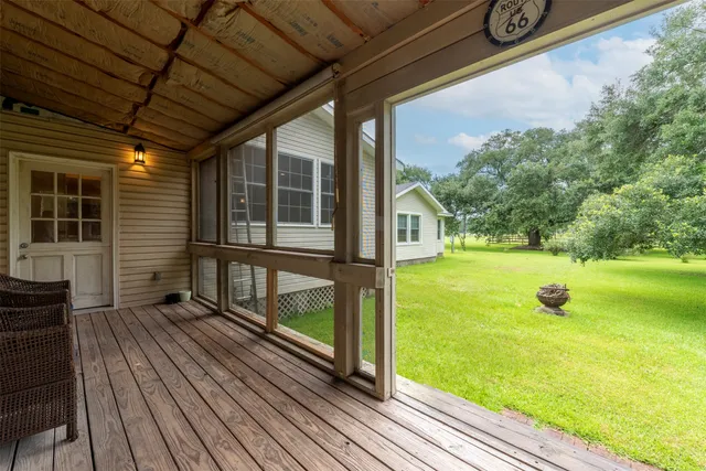 a view of a porch with wooden floor and yard