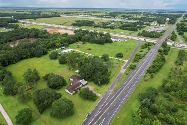 an aerial view of green landscape with trees houses and yard