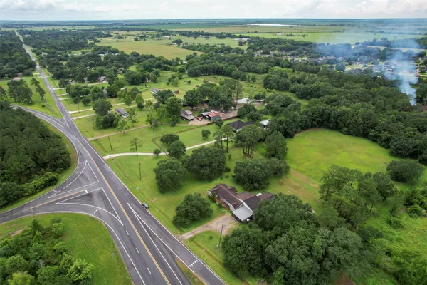 an aerial view of residential houses with outdoor space and trees