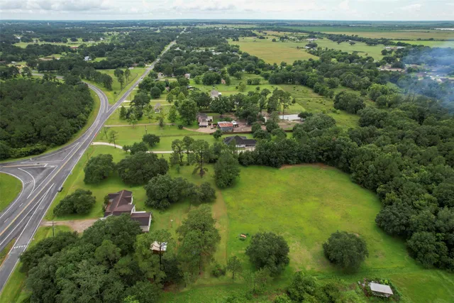an aerial view of residential house with outdoor space and trees around