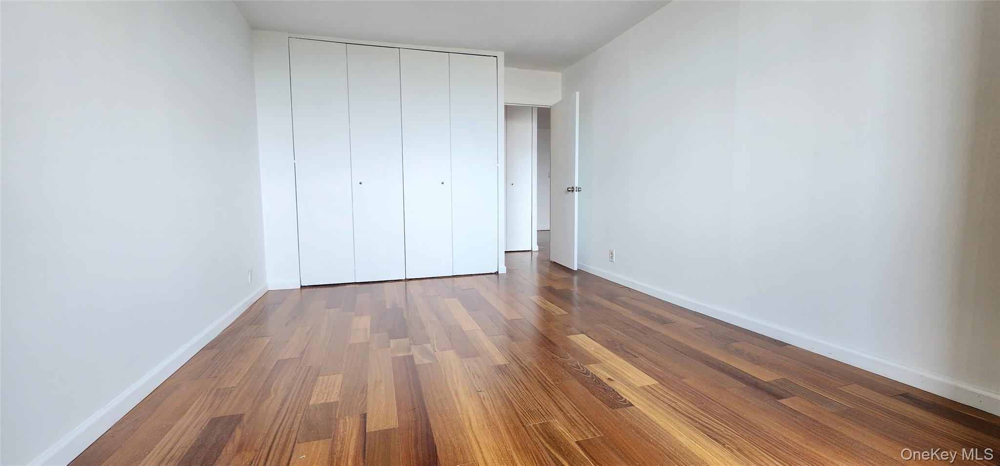 118-17 Union Turnpike, Unit 14E Queens, NY 11375 - Photo 12 of 24 a view of an empty room with wooden floor