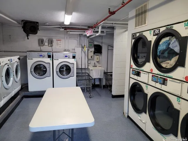 a utility room with dryer washer and a wooden floor