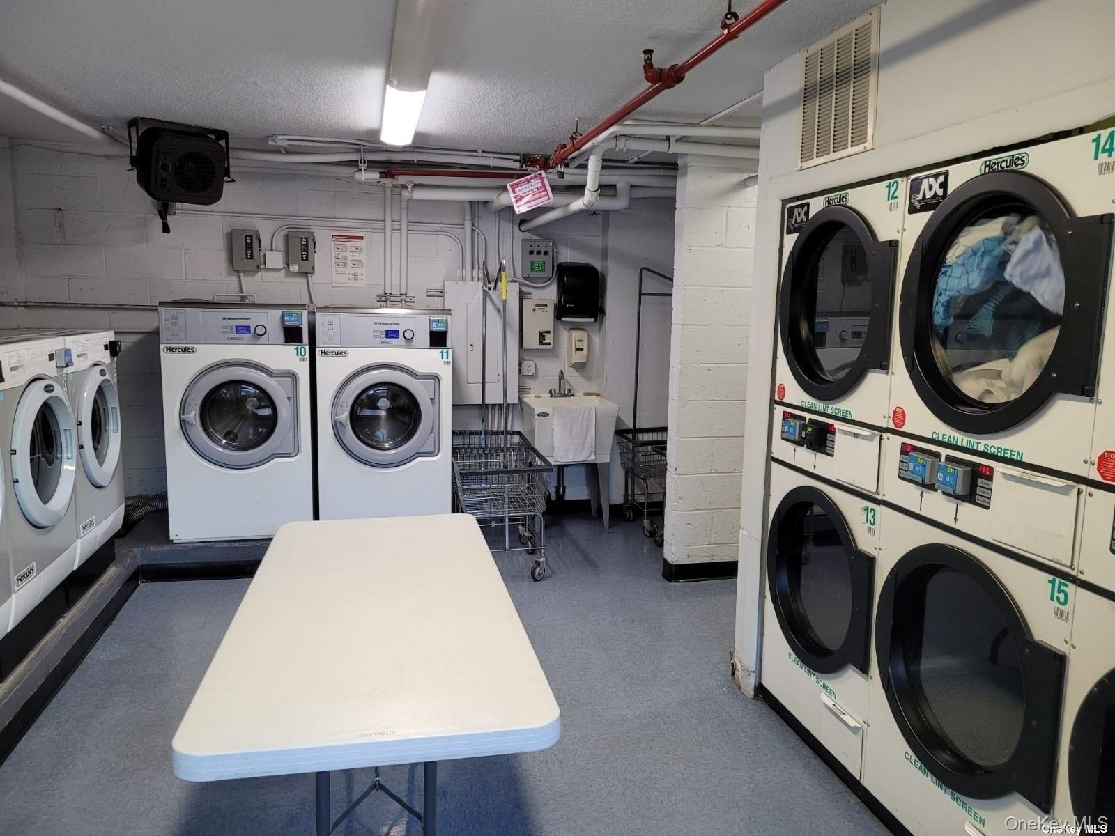 118-17 Union Turnpike, Unit 14E Queens, NY 11375 - Photo 17 of 24 a utility room with dryer washer and a wooden floor