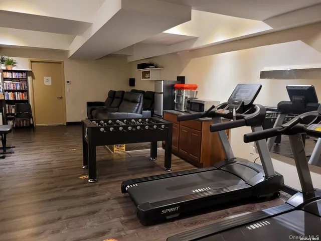 a room with gym equipment and wooden floor