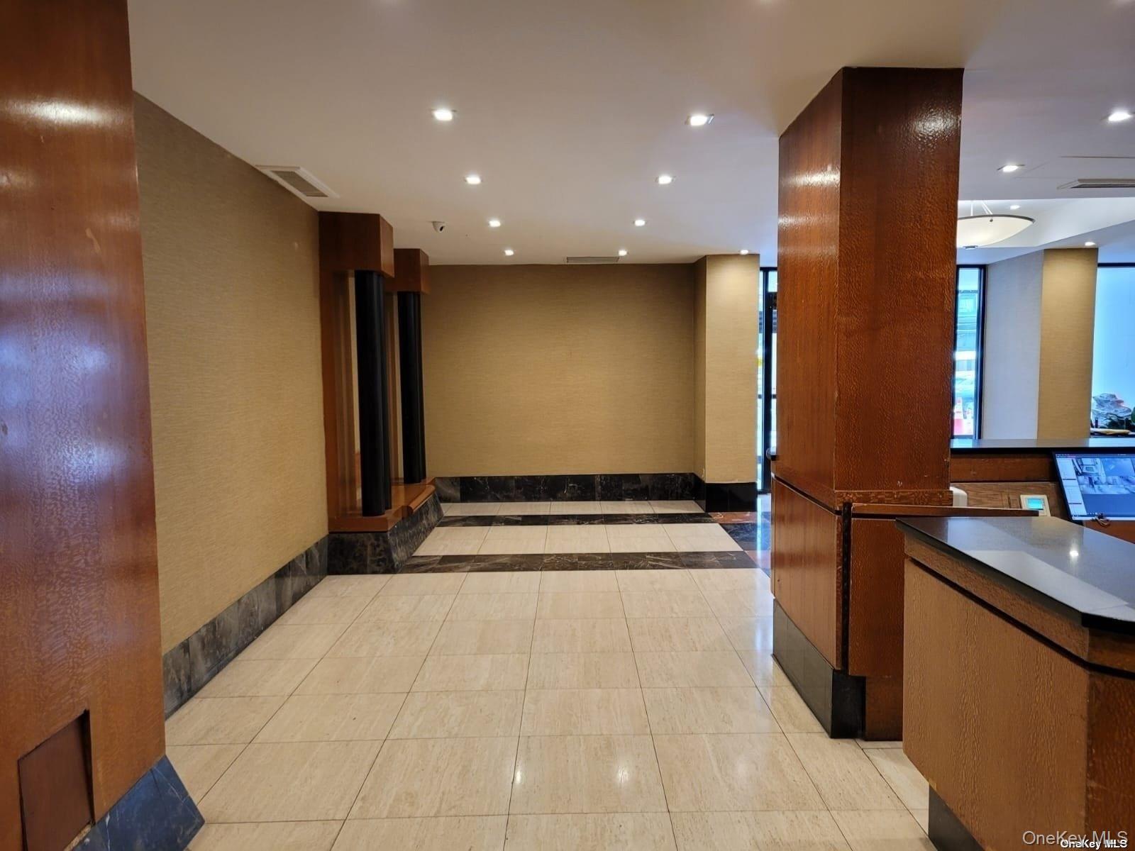 118-17 Union Turnpike, Unit 14E Queens, NY 11375 - Photo 3 of 24 a view of a kitchen with a sink and a mirror