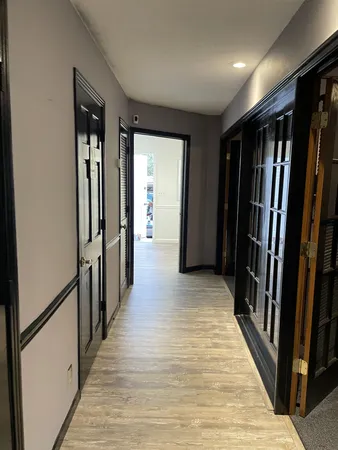 a view of a hallway with wooden floor and stairs