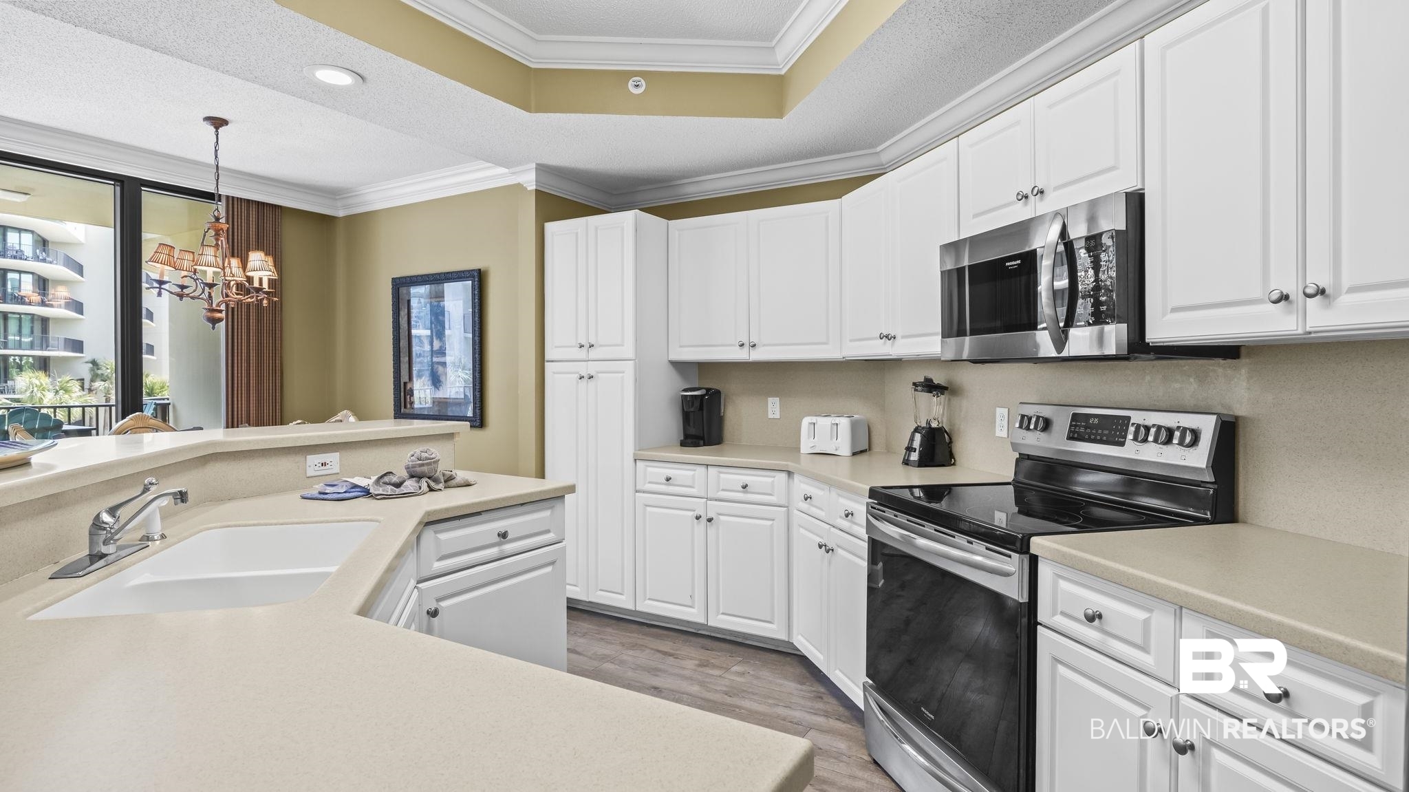 27580 Canal Road, Unit 214 BS 62 Orange Beach, AL 36561 - Photo 4 of 23 Kitchen featuring stainless steel appliances, white cabinetry, light countertops, a chandelier, and a textured ceiling