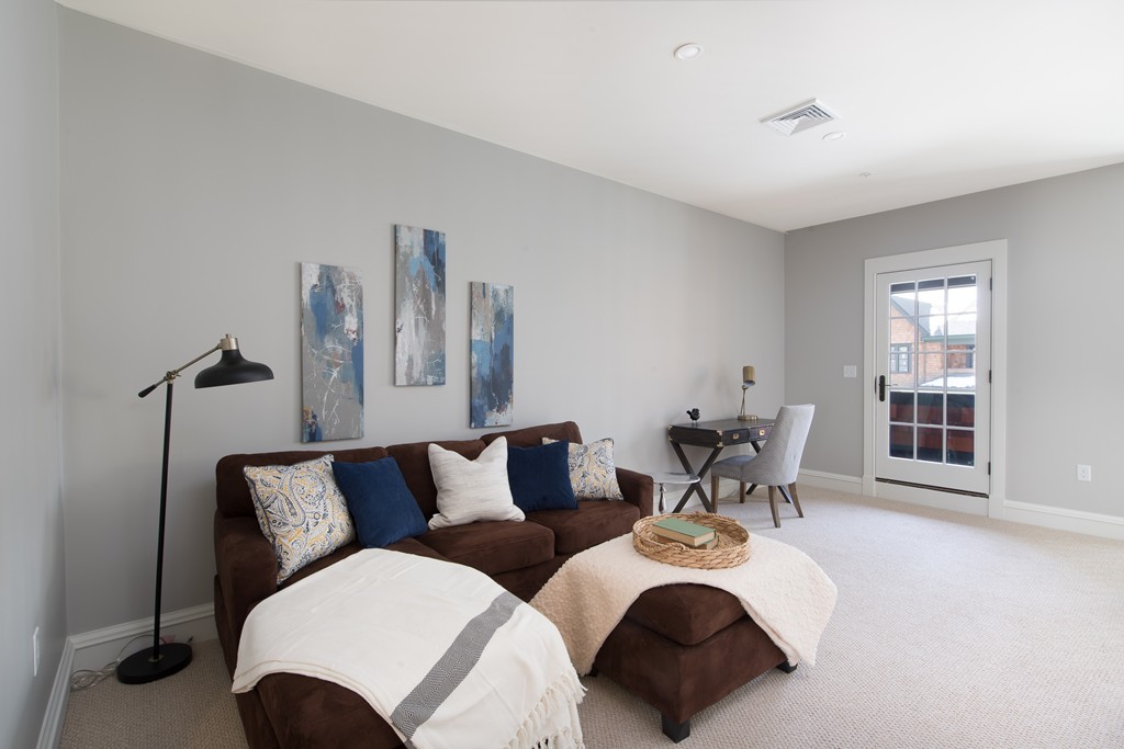 8 Abbey Road, Unit 8 South Walpole, MA 02071 - Photo 6 of 11 a living room with furniture a large window and potted plants