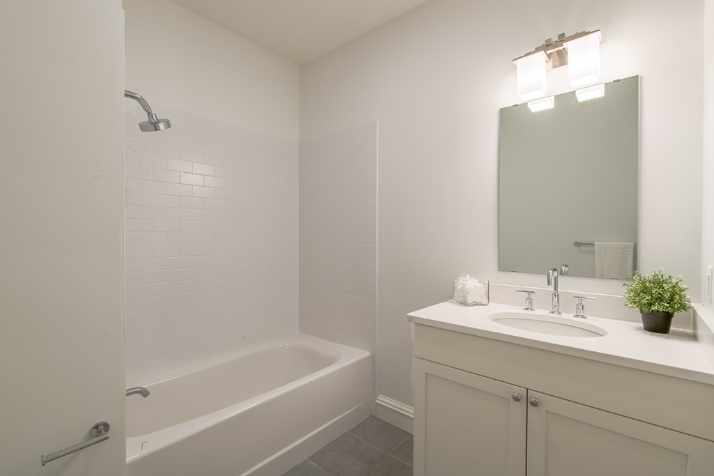 8 Abbey Road, Unit 8 South Walpole, MA 02071 - Photo 8 of 11 a bathroom with a sink a tub and a mirror