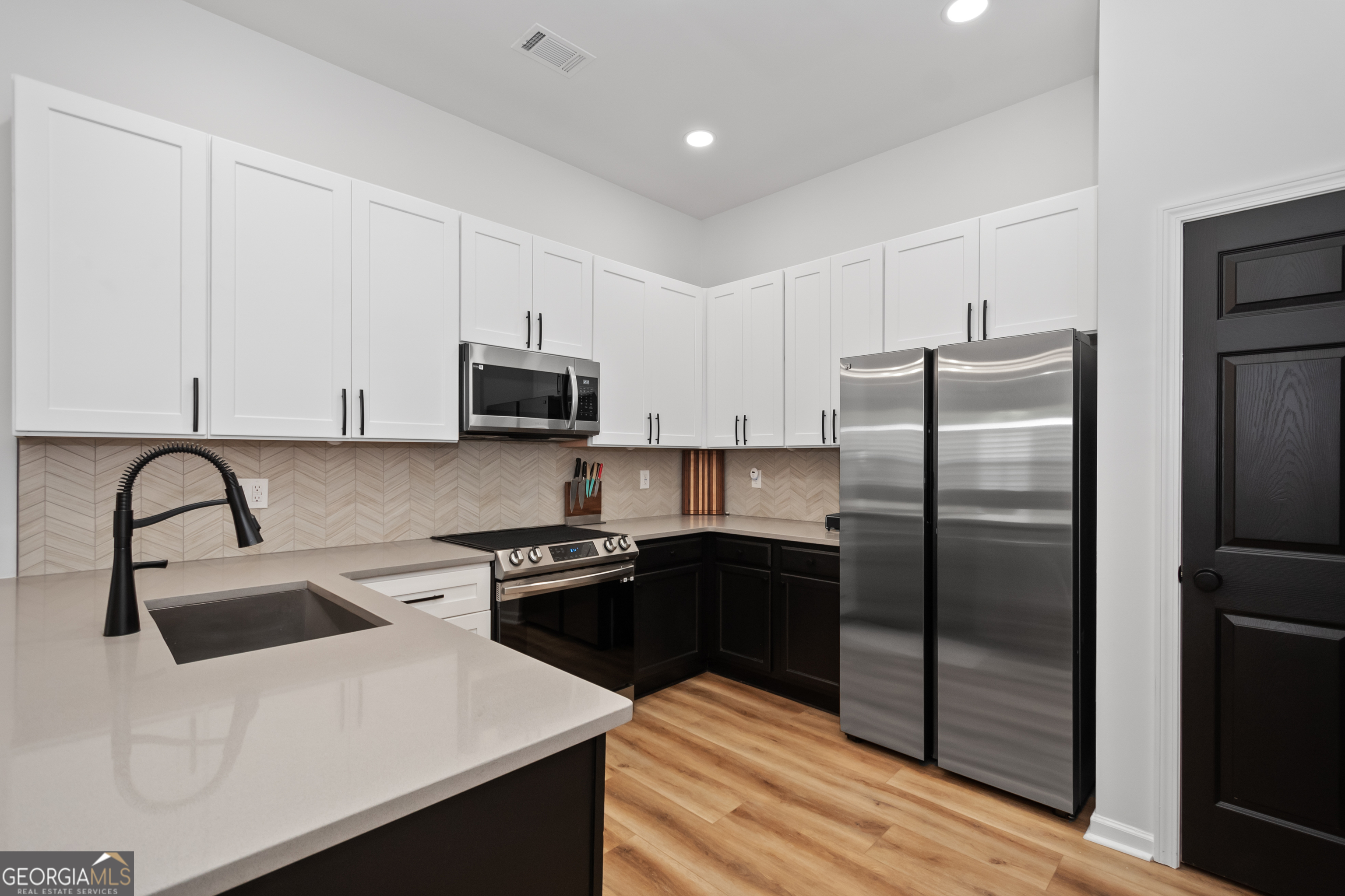 71 Thomaston Street Newnan, GA 30263 - Photo 13 of 38 a kitchen with stainless steel appliances granite countertop a refrigerator a sink a stove and oven