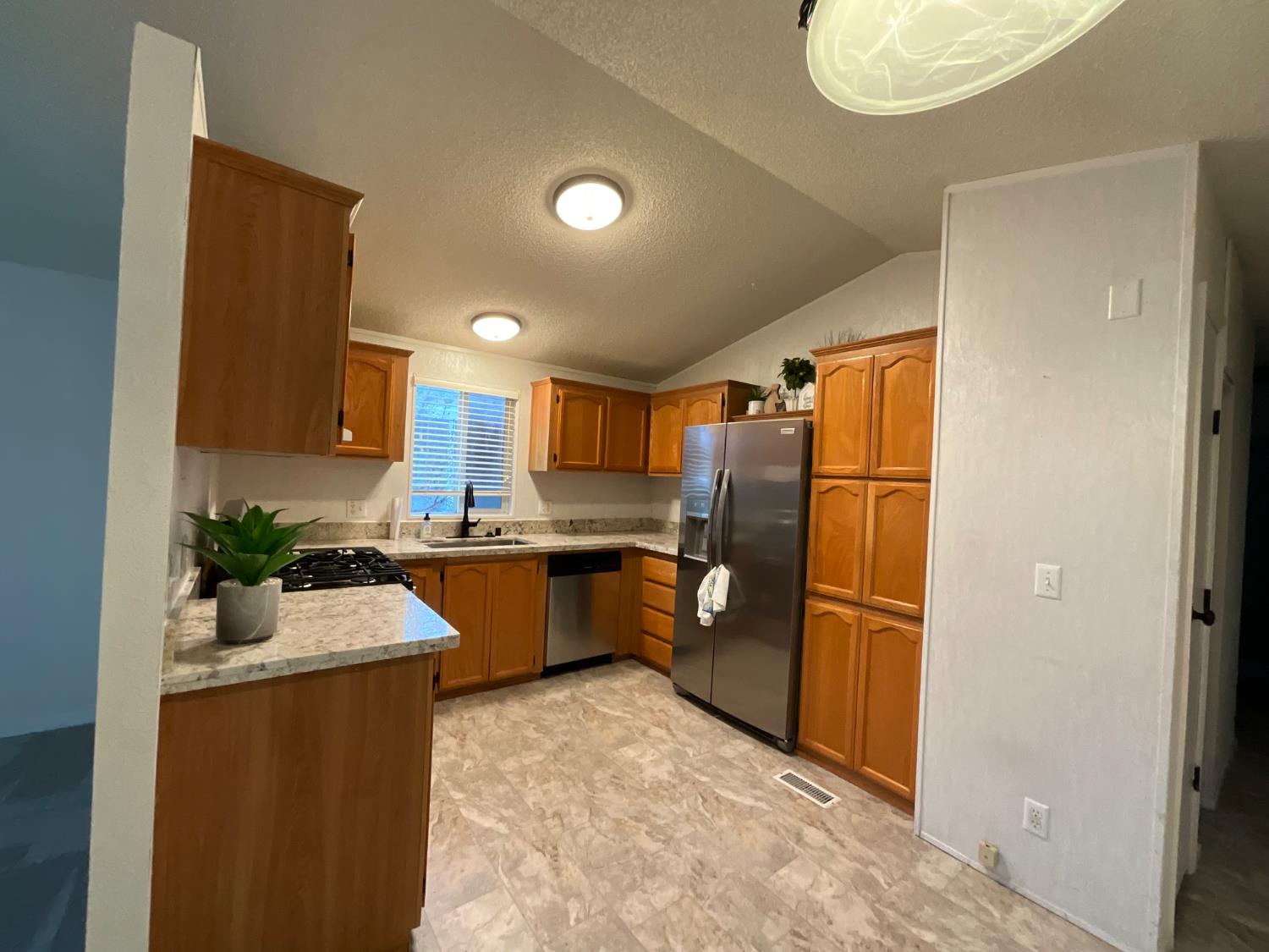 26 Golden Inn Way Rancho Cordova, CA 95670 - Photo 16 of 27 a kitchen with granite countertop a refrigerator and a sink