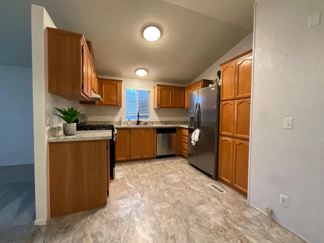 a kitchen with stainless steel appliances granite countertop a refrigerator sink and cabinets