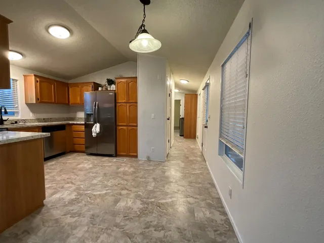 a view of a kitchen with a sink and a refrigerator