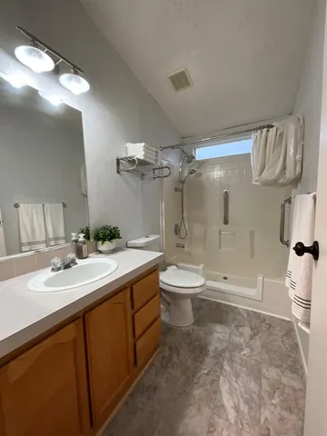 a bathroom with a sink a toilet and shower