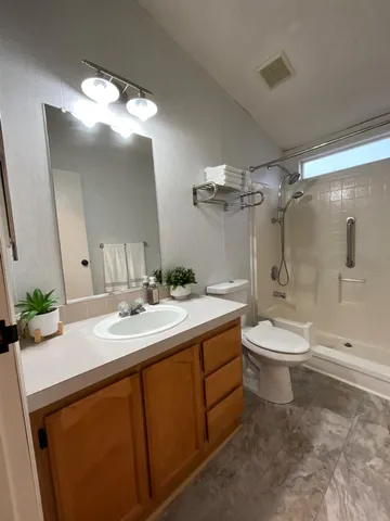a bathroom with a sink a toilet and shower