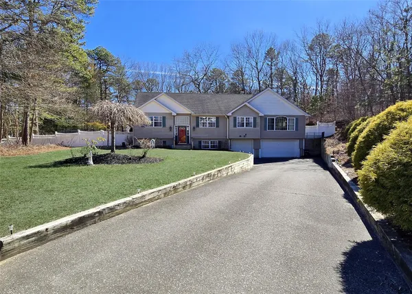 a front view of a house with a yard and trees