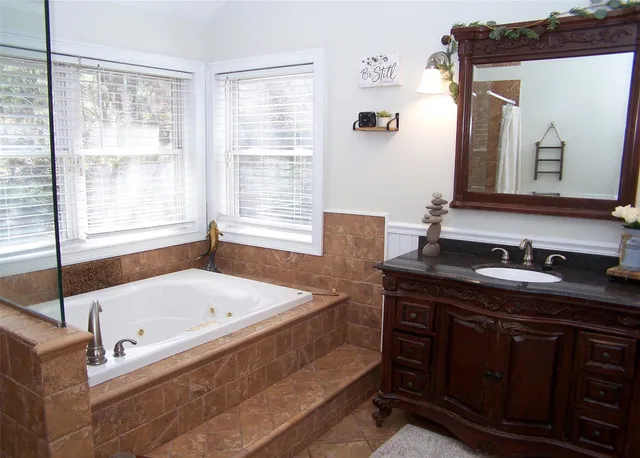 a bathroom with a tub sink and mirror