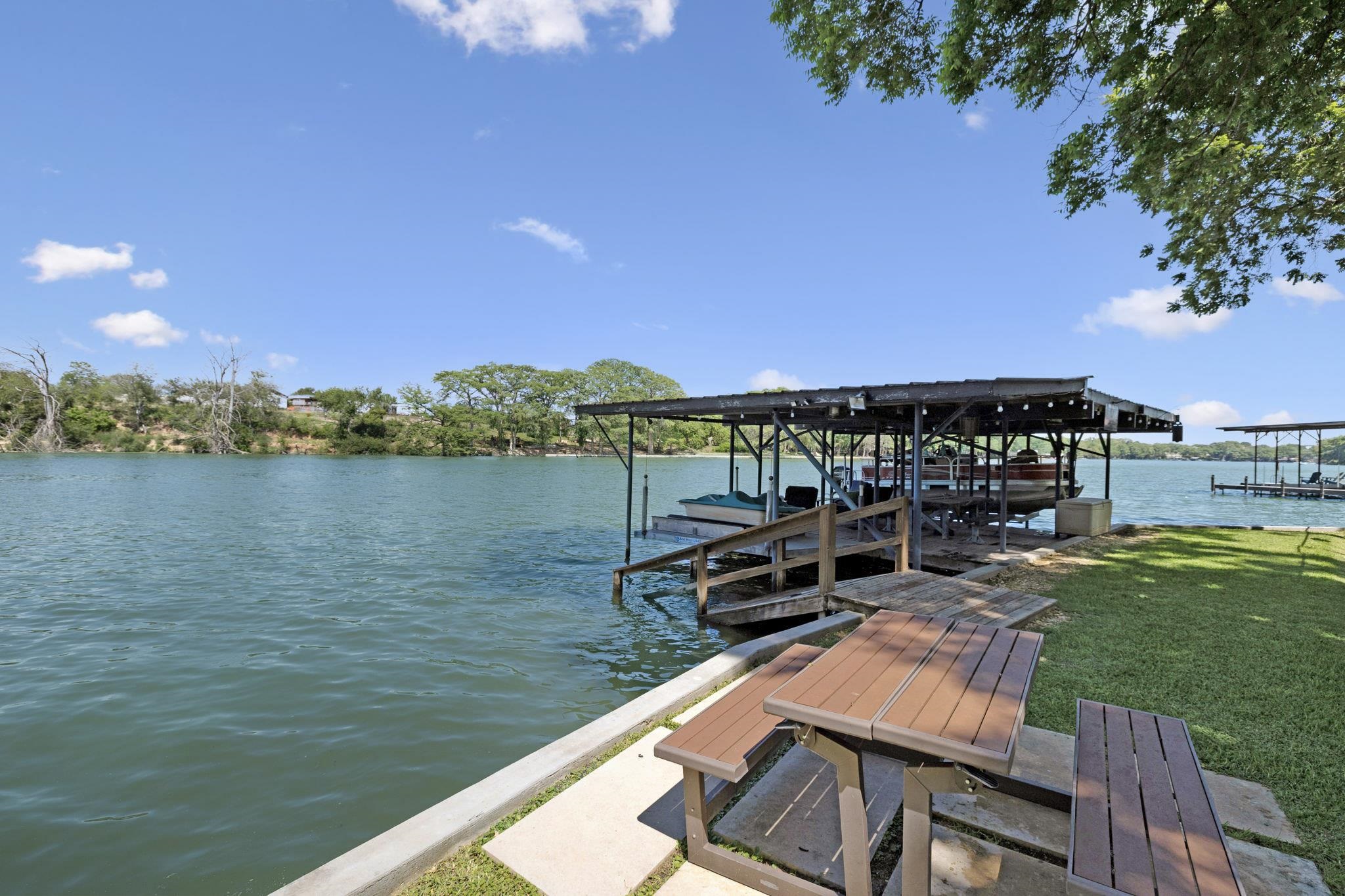 a view of a chairs and table on the river