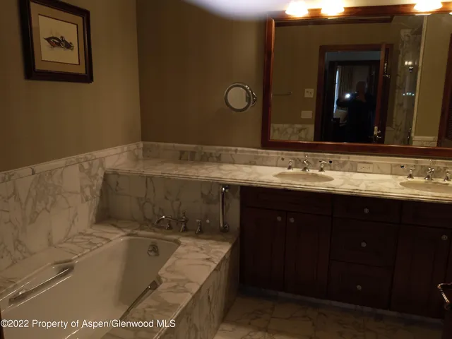a bathroom with a tub sink and mirror