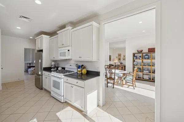 a kitchen with white cabinets and appliances
