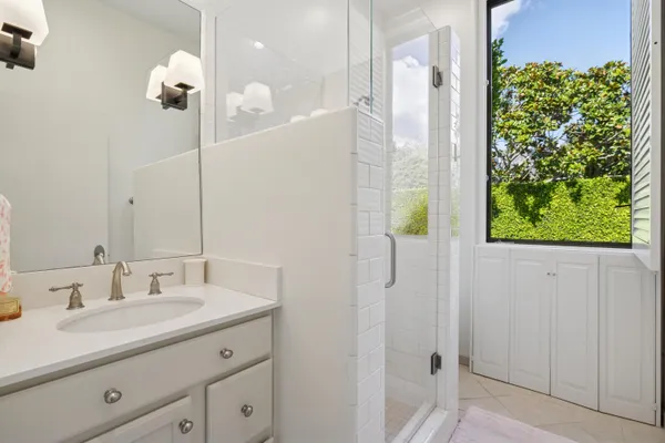 a bathroom with a granite countertop sink a shower and a mirror