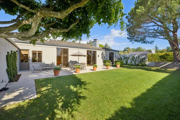 a view of backyard of house with outdoor seating and green space