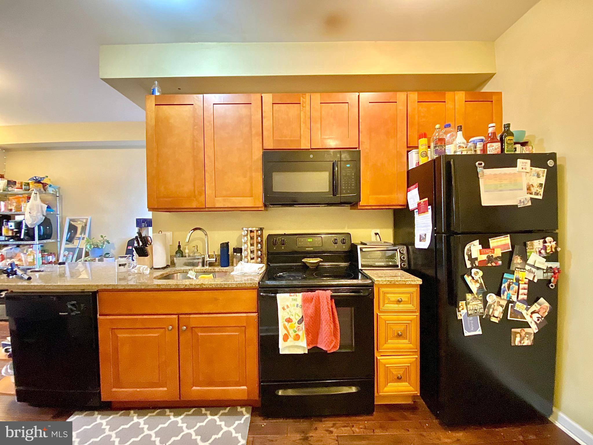 1618 Page Street, Unit B Philadelphia, PA 19121 - Photo 4 of 17 a kitchen with stainless steel appliances granite countertop a stove a sink and a microwave