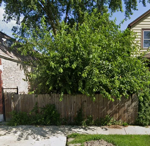 a view of backyard with wooden fence
