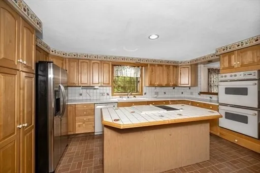 a kitchen filled with stainless steel appliances granite countertop a sink stove and refrigerator